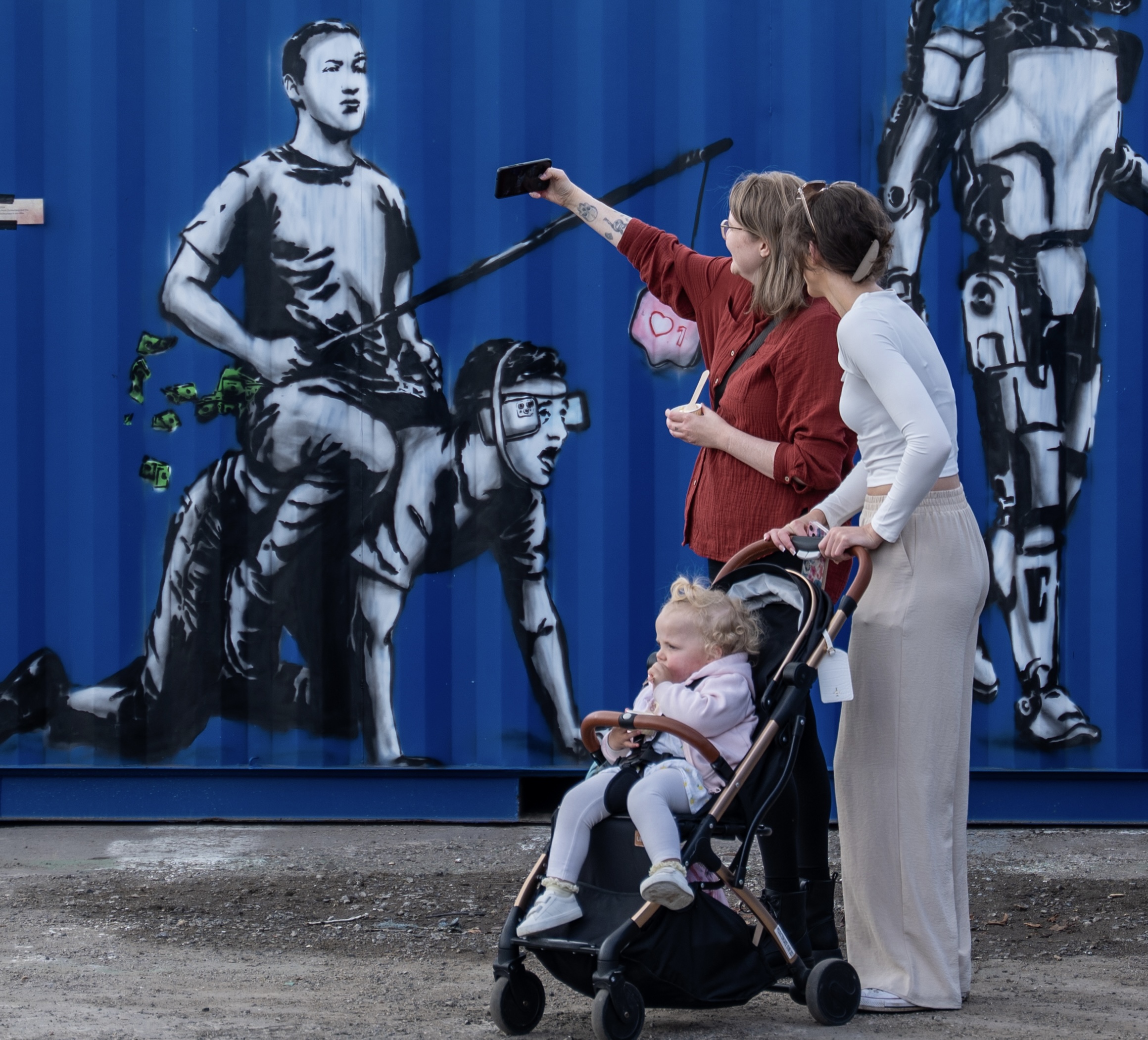 Visitors taking selfies in front of colourful Rebel Bear murals on Boxxs Self Storage containers at Mill Road Industrial Estate