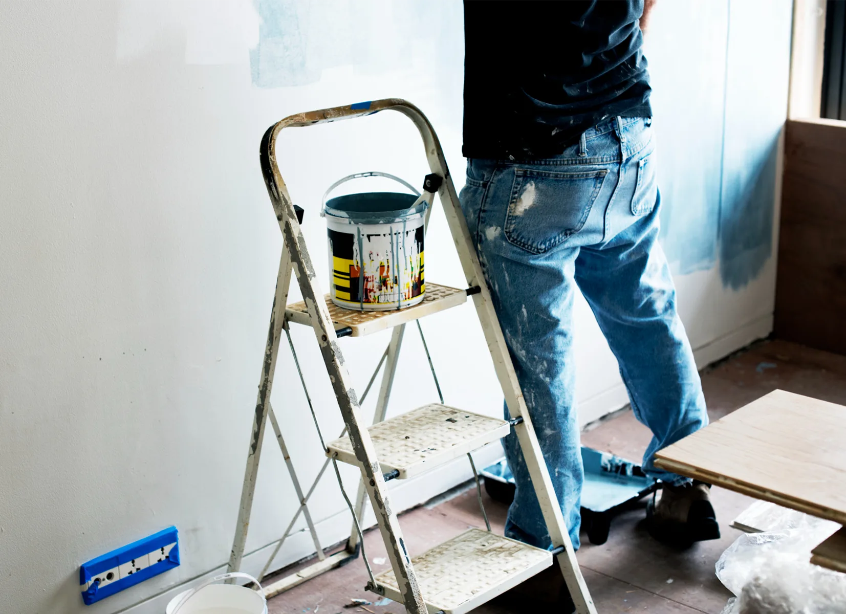 Home renovations in Linlithgow with a decorator painting a room while preparing a property for refurbishment.